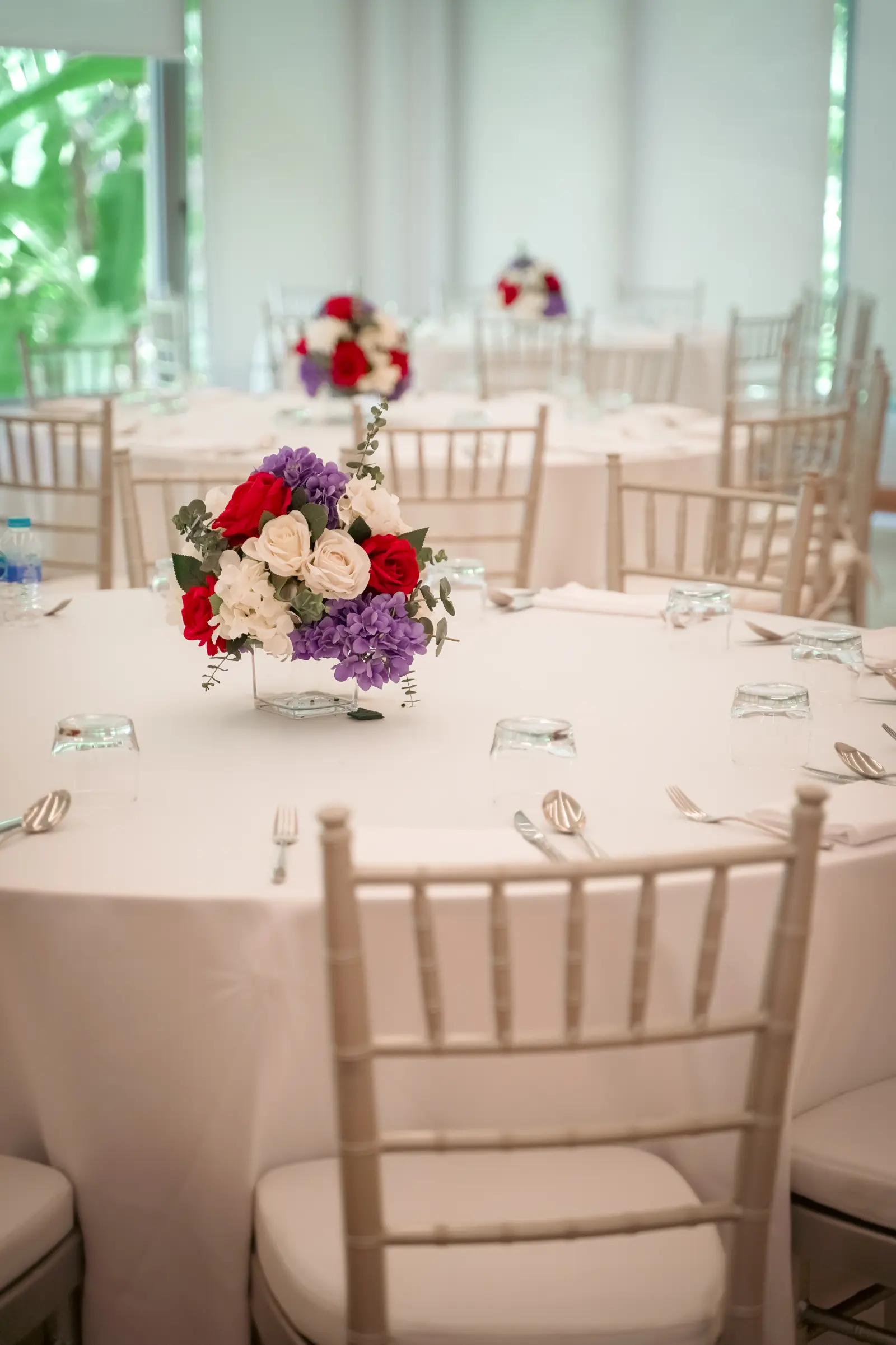 A flower centrepiece and place settings on a hotel event table