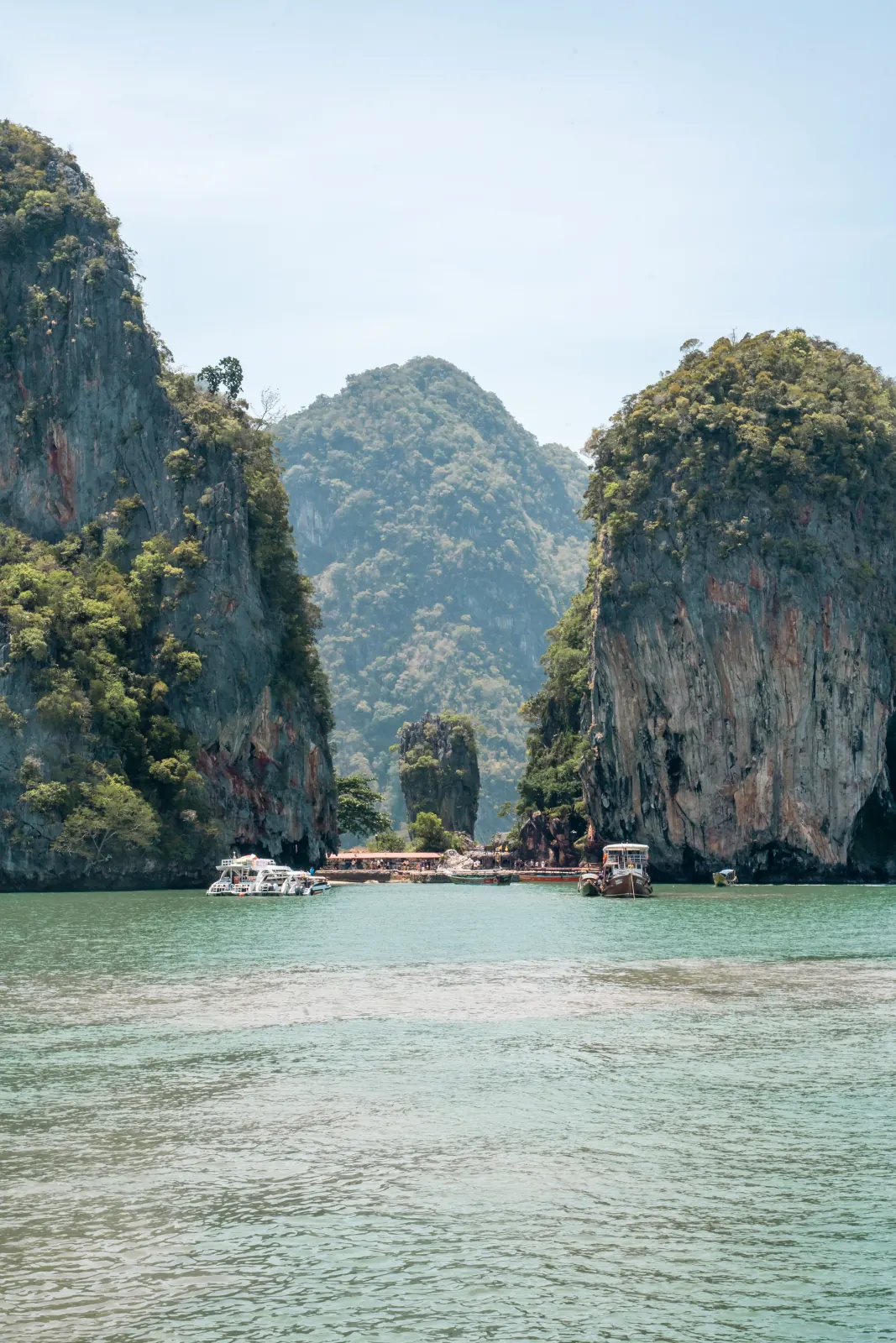 Limestone islands rising from calm green water in Phuket